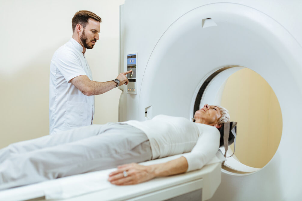 medical technician starting mri scan procedure mature patient examination room